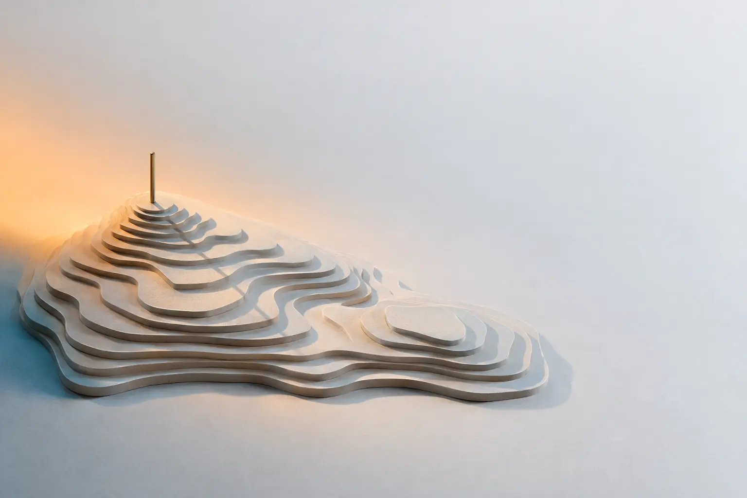A contour terrain model built from stacked layers of pale card, with a single slender brass pin standing at its highest point.